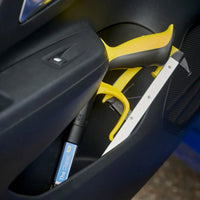 Helping Hand Classic Pro Folder in a car door pocket beside a blue tool, shown as a foldable grabber, side view.