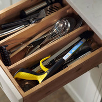 Kitchen drawer with wooden dividers organising utensils, whisks, measuring tape and Helping Hand Classic Pro Folder grabber tool, top view.