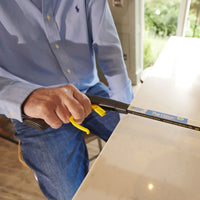 Person using adaptive kitchen knife and Helping Hand Classic Pro Reacher on counter, in use.