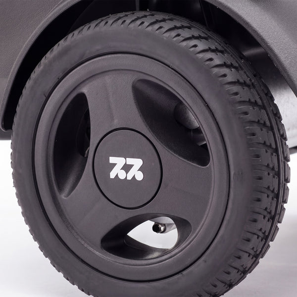 Urathon Hero Carbon Fibre Powerchair tyre with three-spoke hubcap and 7.2 logo, close-up.