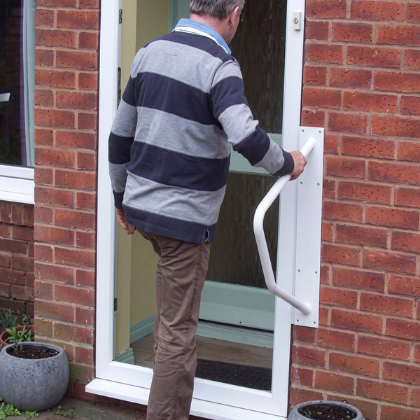 Homecraft Handy Rail used by an older adult for support at a doorway with steps, in use.