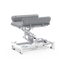 Medi-Plinth hydraulic changing table with height adjustment, wipe-clean upholstery, side rails and casters, side view.