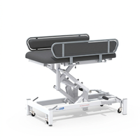 Medi-Plinth hydraulic changing table, MRSA-resistant with cushioned surface, side rails, white frame on wheels, side view.