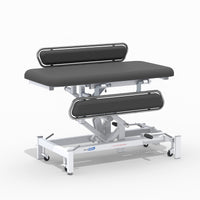 Medi-Plinth Hydraulic Changing Table with MRSA-resistant metal frame, black cushions and wheels, side view.