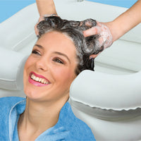 Woman having her hair washed in an Aidapt Inflatable Hair Wash Basin, shampoo being massaged in, in use.