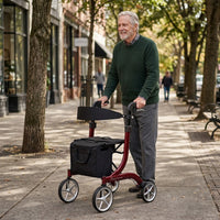 Older man using Integrity Aries Premium Rollator by Integrity Mobility Solutions on city pavement, trees in background, in use view.