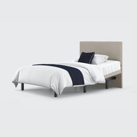 Jade Motion Adjustable Bed by Opera Beds with white bedding, navy throw, and two pillows, front view.