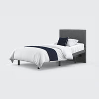 Opera Beds Jade Motion Adjustable Bed with grey headboard, white bedding and navy throw on plain background, front view.