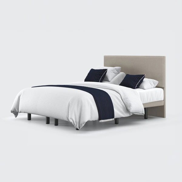Opera Beds Jade Motion Adjustable Bed with beige headboard, white bedding, navy accents and four pillows, front view.