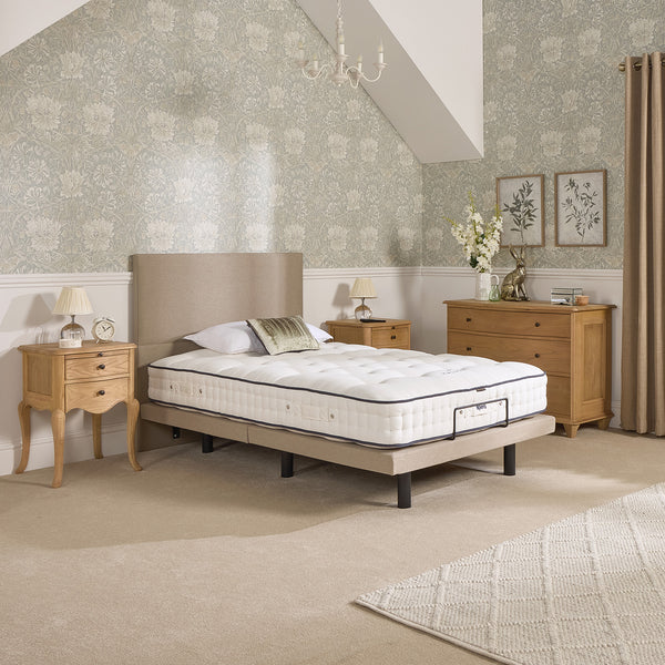 Opera Beds Jade Motion Adjustable Bed in a room with wooden furniture and floral wallpaper, front view.