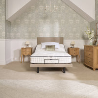 Opera Beds Jade Motion Adjustable Bed with two bedside tables, dresser and floral wallpaper, bedroom front view.