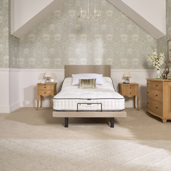 Opera Beds Jade Motion Adjustable Bed with two bedside tables, dresser and floral wallpaper, bedroom front view.
