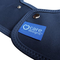 Care Designs Tabard Style Adult Bib with stitched edges, metal snaps and blue heart logo label, close-up view.