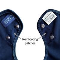 Care Designs Tabard Style Adult Bib with two metal snaps and reinforced patches by the fasteners, close-up view.