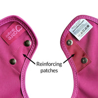 Care Designs Junior Tabard Style Bib with reinforced patches and metal snap buttons, text and arrows highlighting features, close-up.