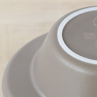 Upside-down ORNAMIN Keep Warm Bowl showing non-slip base on light wooden surface, close-up.