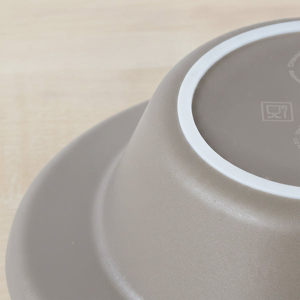 Upside-down ORNAMIN Keep Warm Bowl showing non-slip base on light wooden surface, close-up.