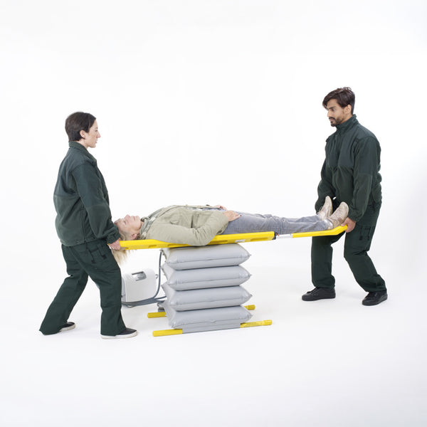 Mangar ELK Lifting Cushion in use with two people assisting a person, white background, side view.