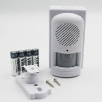 Easy Link motion activated memo reminder with buttons and speaker, shown with mounting hardware and AA batteries, front view.