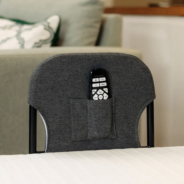 Motion Bed Grab Rail by Opera Beds stored in a pocket on chair backrest beside adjustable beds, side view.