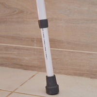 NRS Mowbray Lite Toilet Aid adjustable leg with height markings and rubber tip next to bathroom support rails, close-up.