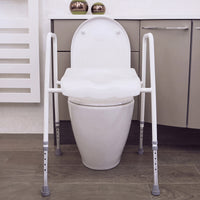 NRS Mowbray Lite Toilet Aid with handles and adjustable height next to modern bathroom cabinets, front view.