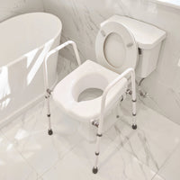 Toilet aid with handrails placed over a toilet next to a bathtub and tiled floor, side view.
