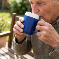 Elderly man using ORNAMIN Mug with Internal Cone outdoors on a sunny day, in use view.
