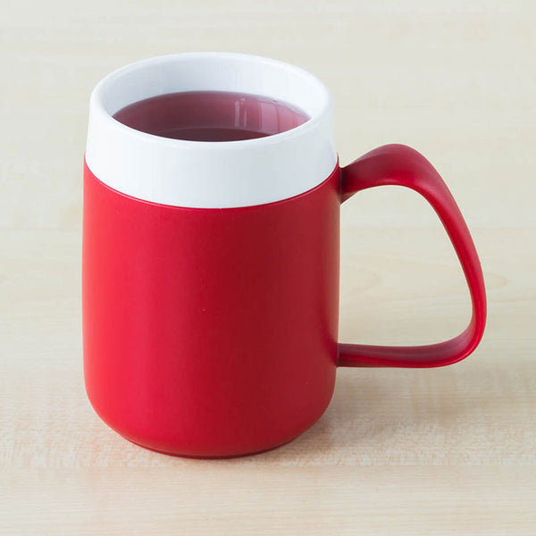 ORNAMIN Mug with Internal Cone filled with dark liquid on a light wooden surface, side view.