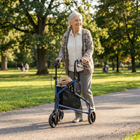 Elderly woman using NRS Three Wheel Steel Rollator for support while walking in the park, outdoors in use.