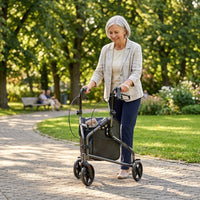 Older woman using NRS Three Wheel Steel Rollator while walking on a sunny park path, in use view.