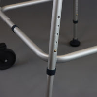 NRS Walk Safe Walking Frame showing adjustable holes and rubber tips, close-up view.