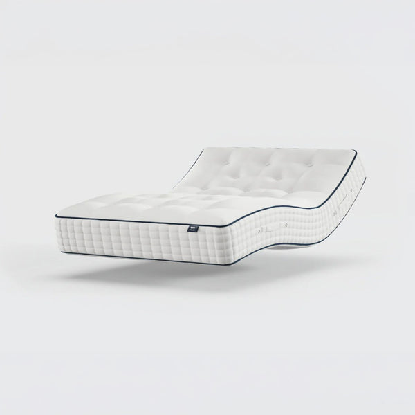 Opera Beds Premium Natural Pocket 2500 Mattress with dark edging, bent and floating over a plain white background, angled view.