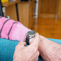 Person checking a Ravencourt Living Radio Controlled Digital Talking Watch indoors, in use view.