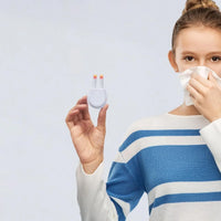 Woman holding tissue and using Lifemax Rechargeable Hay Fever and Allergy Reliever, wearing striped sweater, in use.