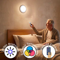 Man in bed using Lifemax Rechargeable Motion Ceiling Light with icons for 280lm, 3 colour temperatures and remote control, in use.
