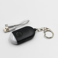 Lifemax Rechargeable Personal Alarm keyring with torch and USB cable on white surface, top view.