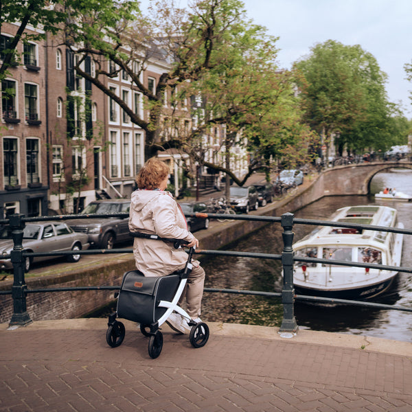 Rollz Flex 2-in-1 Rollator and Shopping Trolley in Jungle Green beside a canal, in use, side view.