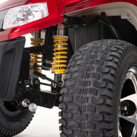 Drive Safari Scooter front all-round suspension with yellow coil springs and large tyre under fender, close-up.