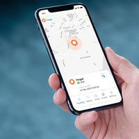 Hand holding a phone displaying Ravencourt Safer Walking GPS Locator app map with location markers, in use.