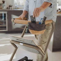 Person with Saljol Indoor Rollator and pouch holding remotes and glasses in kitchen, in use view.
