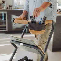 Remote being placed in the Saljol Indoor Rollator pouch in a modern kitchen, in use.