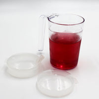 Homecraft Shatterproof Mug with handle, filled with liquid, shown with two anti-spill lids on white background, front view.