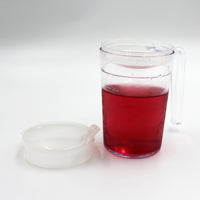 Homecraft Shatterproof Mug with handle, filled with liquid, next to detached anti-spill lid on white background, front view.