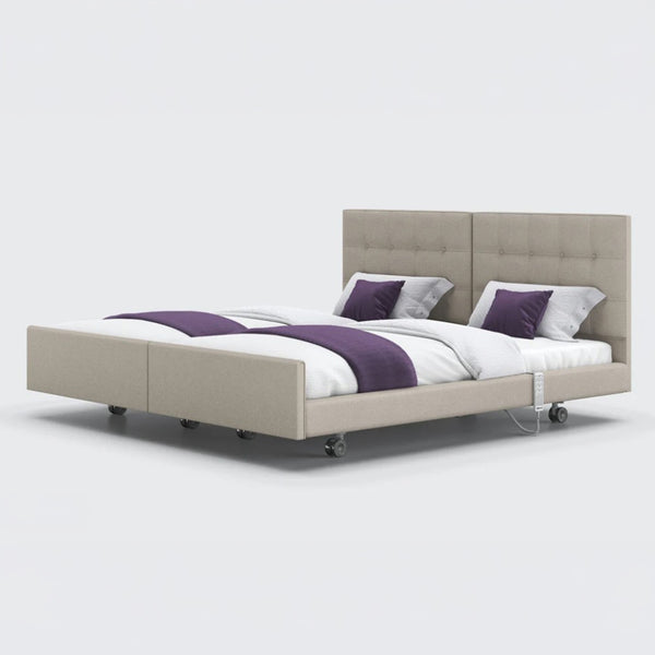 Twin adjustable profiling bed with remote, upholstered headboard, side rails and wheels, by Opera Beds, side view.