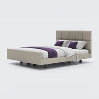 Signature Comfort Dual Profiling Bed with tall tufted headboard, white bedding and purple accents, front view.