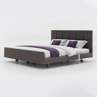 Signature Comfort Dual Profiling Bed with tufted headboard, leatherette frame and purple pillows, front view.