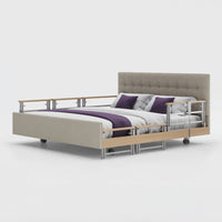 Opera Beds Signature Comfort Plus Dual Profiling Bed with drop side rails and wheels, white background, front view.