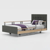 Opera Beds Signature Comfort Plus Profiling Bed with wooden accents, wheels, and purple blanket, front view.