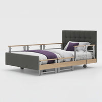 Opera Beds Signature Comfort Plus Profiling Bed with adjustable side rail, white bedding and purple blanket, side view.